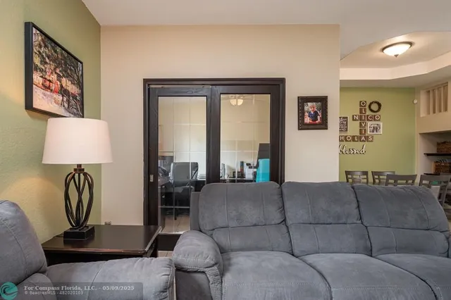 a living room with furniture a lamp and a large window
