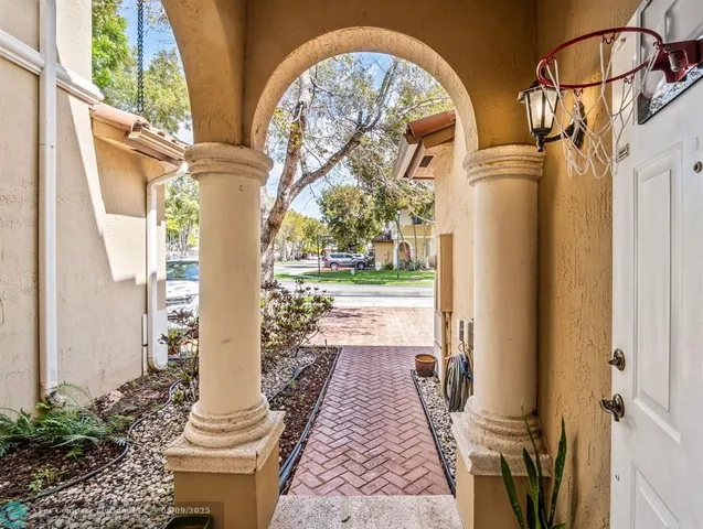 a view of a hallway with wooden floor and glass windows