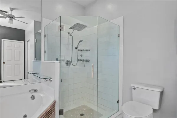 a bathroom with a bathtub shower sink vanity and toilet