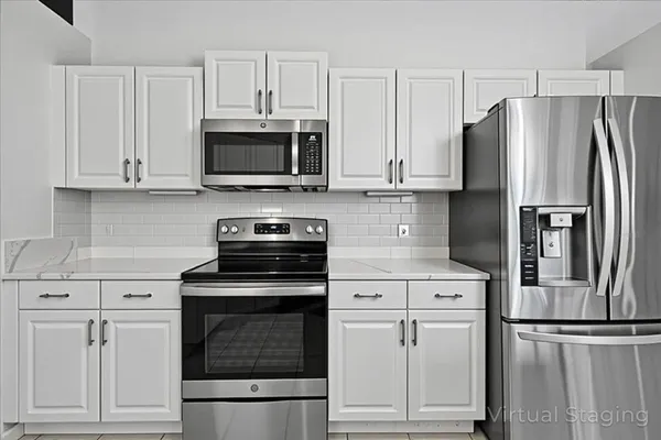 a kitchen with cabinets stainless steel appliances and a counter space