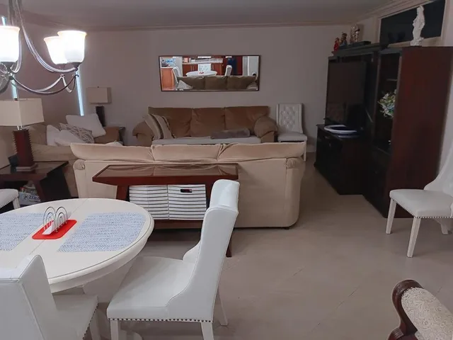 a living room with furniture a flat screen tv and a lamp