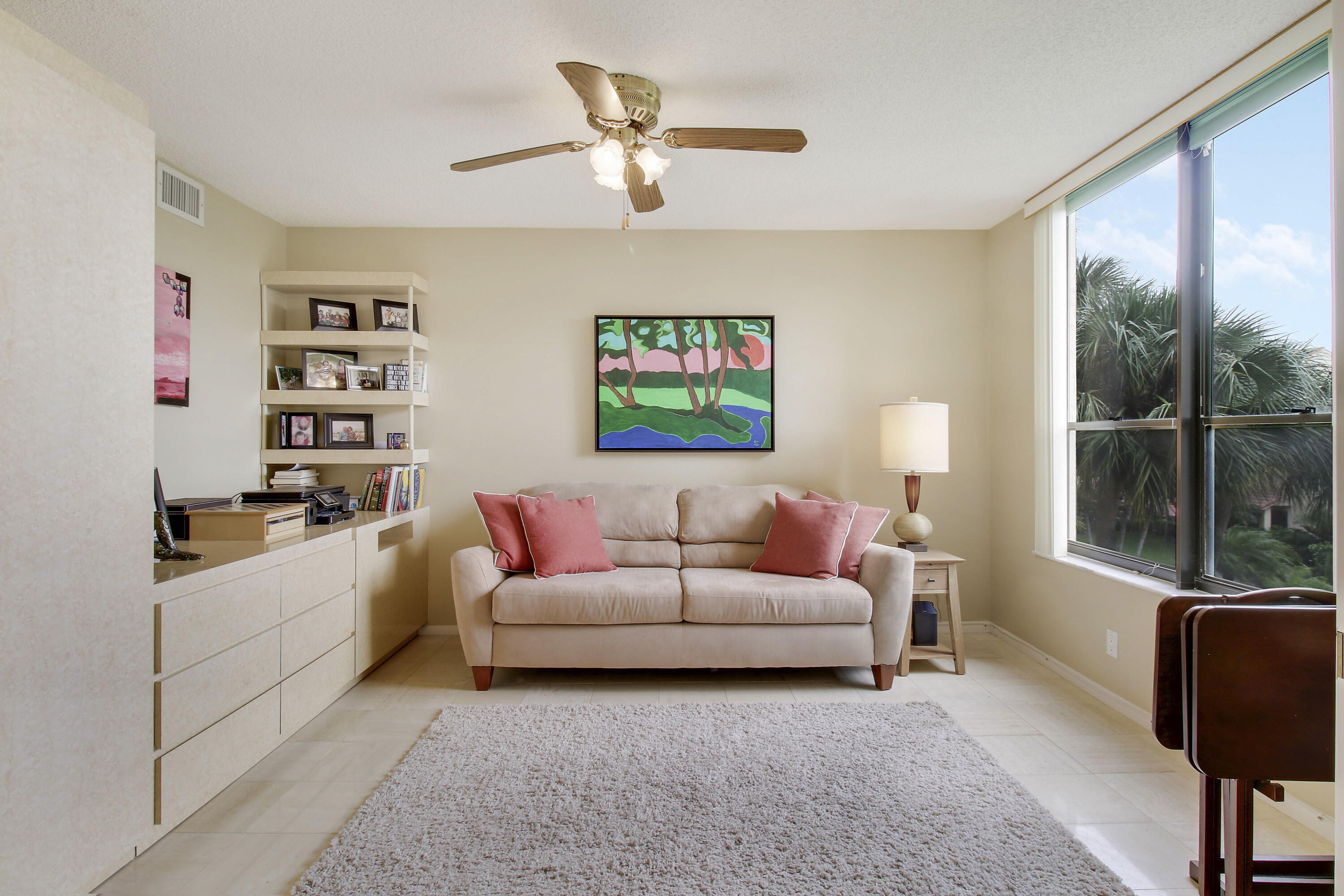 7201 Promenade Drive, Unit 301 Boca Raton, FL 33433 - Photo 16 of 40 a living room with furniture a large window and a flat screen tv
