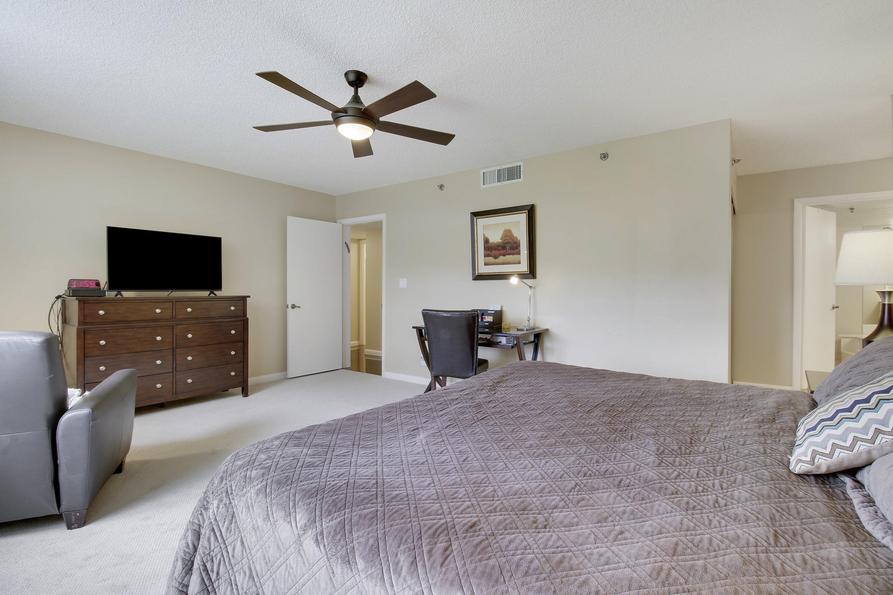 7201 Promenade Drive, Unit 301 Boca Raton, FL 33433 - Photo 19 of 40 a bedroom with a bed and a flat screen tv