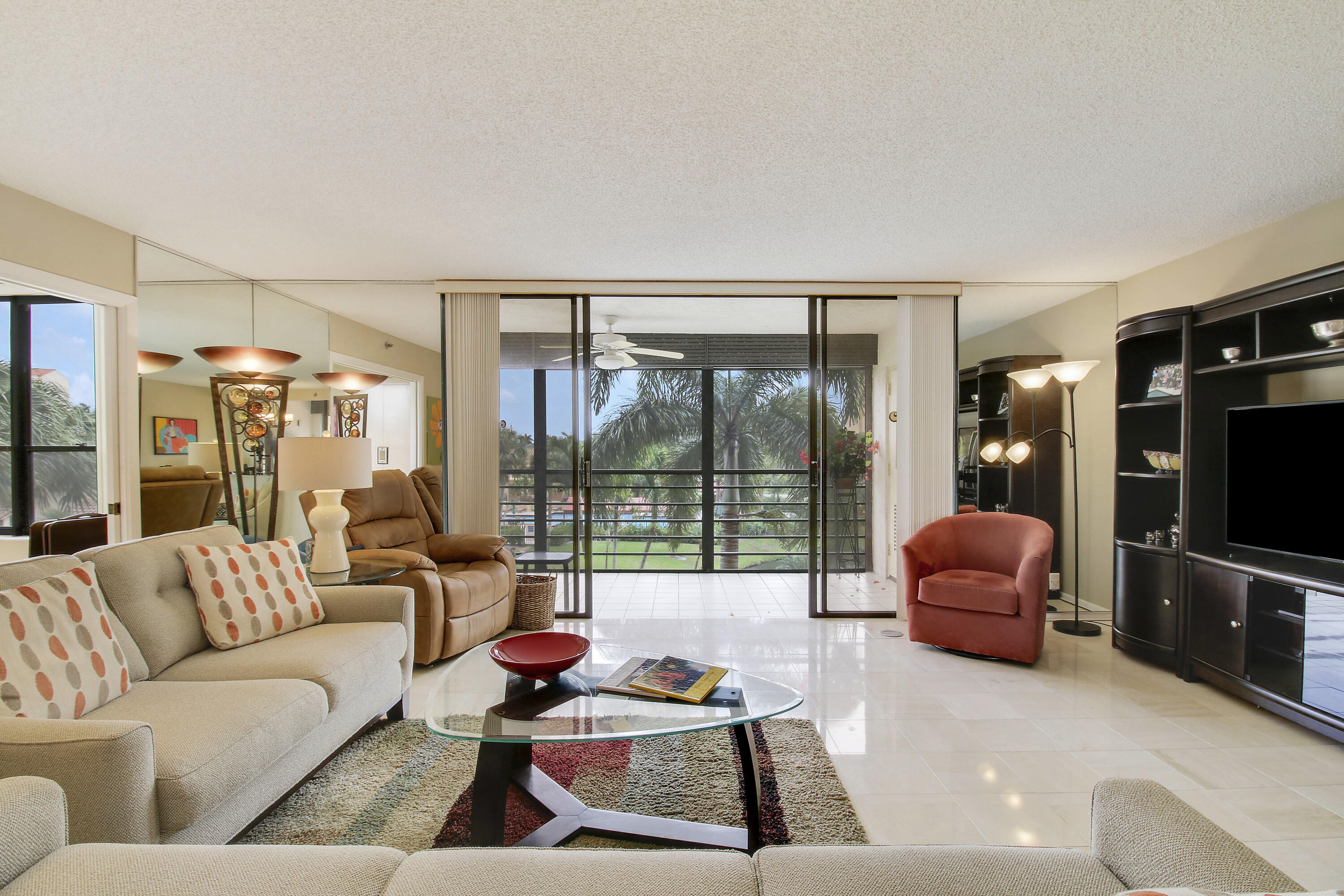 7201 Promenade Drive, Unit 301 Boca Raton, FL 33433 - Photo 5 of 40 a living room with furniture and a flat screen tv