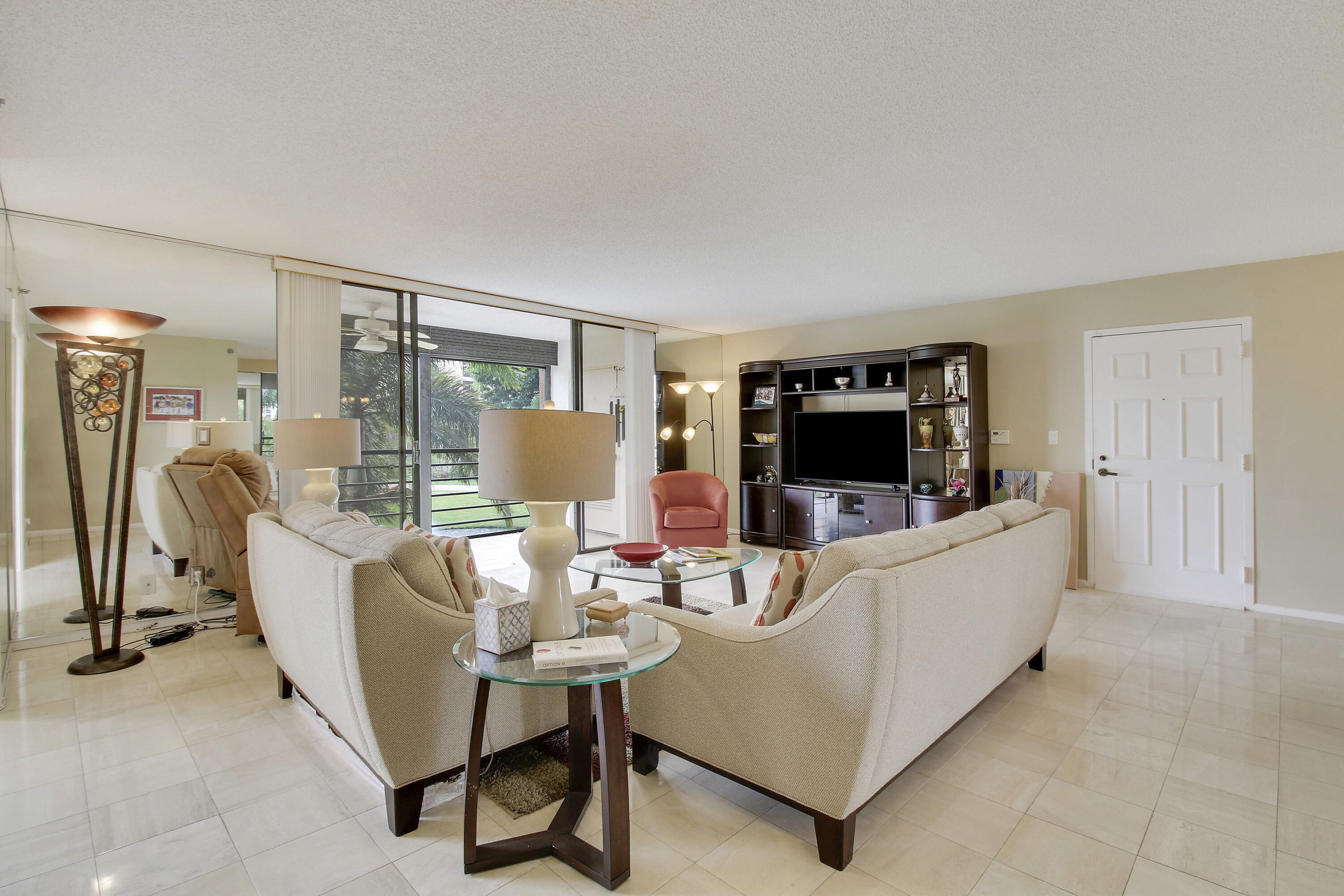 7201 Promenade Drive, Unit 301 Boca Raton, FL 33433 - Photo 6 of 40 a living room with furniture and a flat screen tv