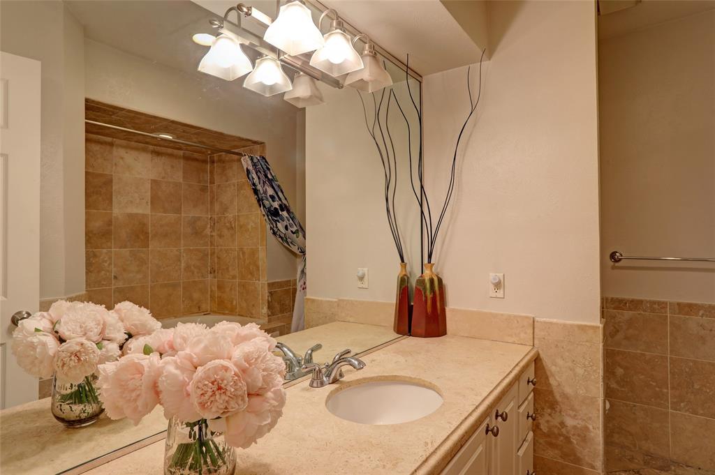 7736 Meadow Road, Unit 102 Dallas, TX 75230 - Photo 20 of 25 a bathroom with a granite countertop sink a mirror and shower