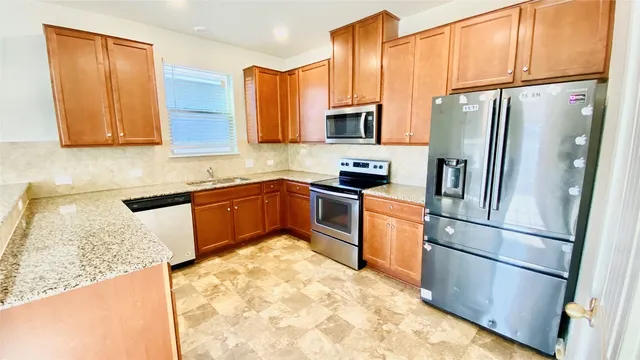 a kitchen with stainless steel appliances granite countertop a refrigerator sink and cabinets