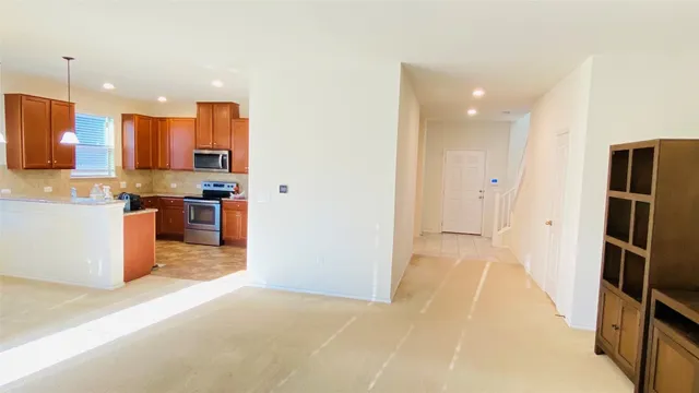 a kitchen with stainless steel appliances kitchen island granite countertop a refrigerator and a sink