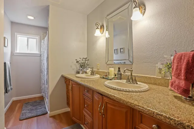 a bathroom with a granite countertop sink and a mirror