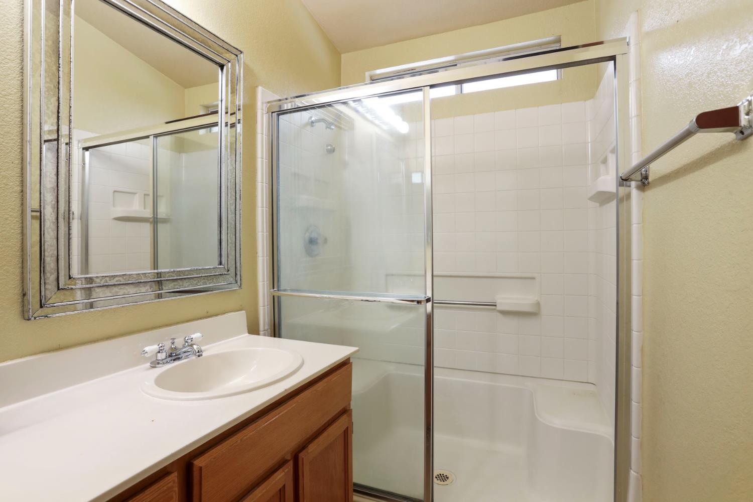 1601 Spring Court Tracy, CA 95376 - Photo 37 of 49 a bathroom with a shower sink vanity and mirror