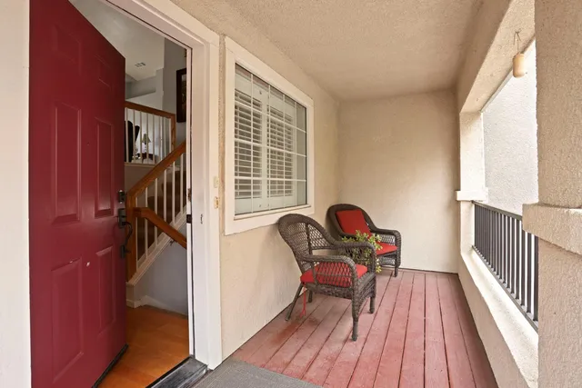 a view of a hallway with wooden floor and stairs