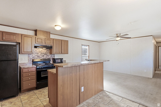 2875 North Hill Field Road, Unit 62 Layton, UT 84041 - Photo 16 of 34 Kitchen featuring wood-finish cabinetry, tile flooring, and a breakfast bar