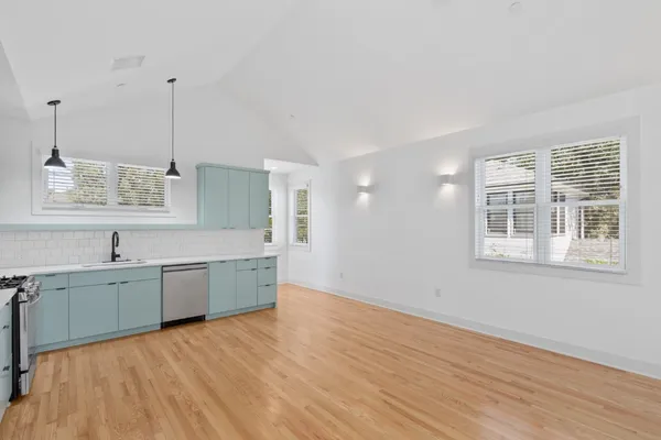 a large kitchen with kitchen island a sink dishwasher a stove and a large window