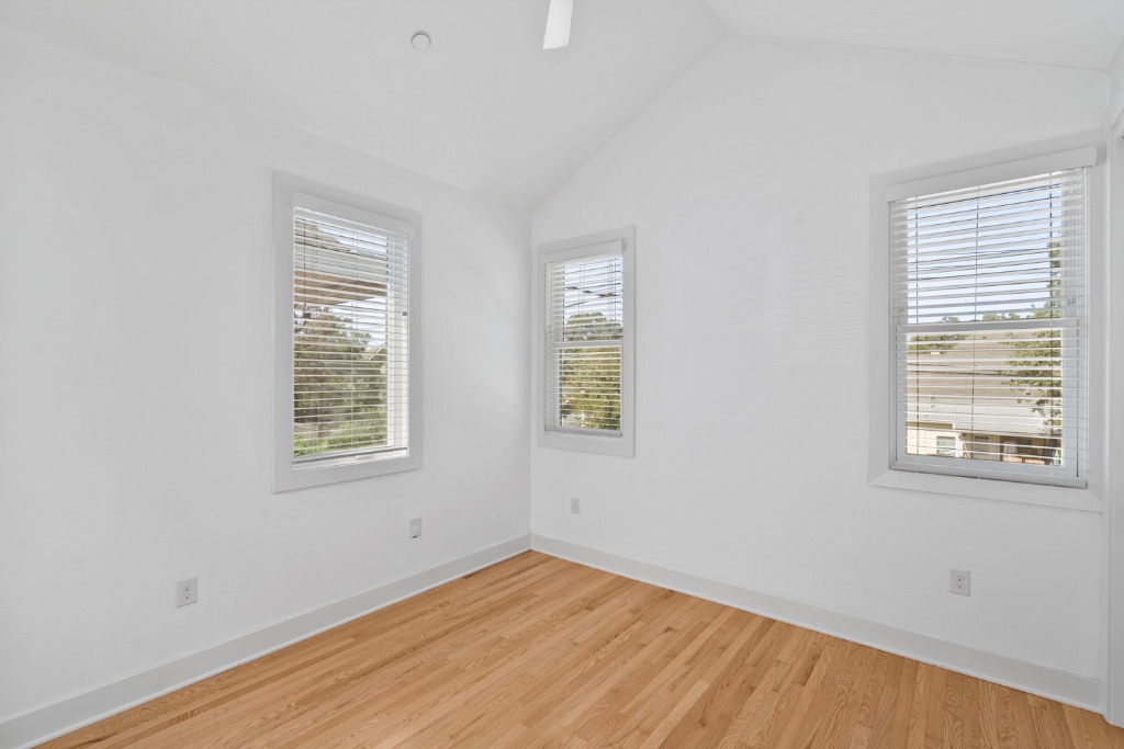 4006 Avenue C, Unit D Austin, TX 78751 - Photo 8 of 14 Empty room with wood finished floors and lofted ceiling