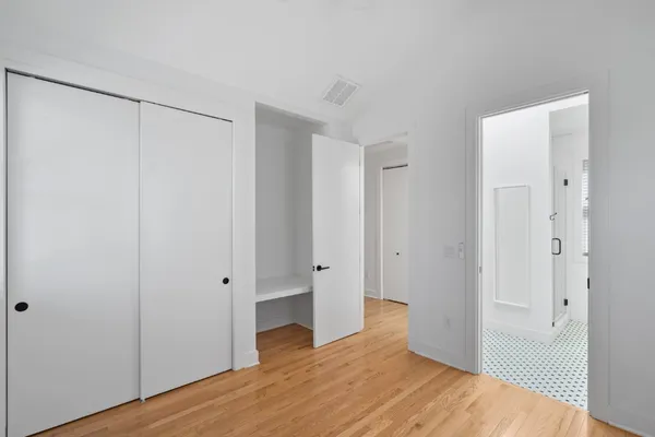 a view of an empty room with wooden floor