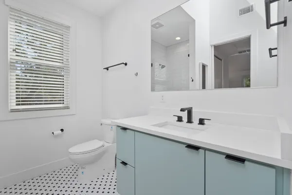 a bathroom with a sink a toilet and a mirror