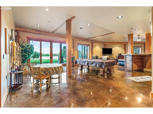 a dining hall with stainless steel appliances kitchen island granite countertop a table and chairs