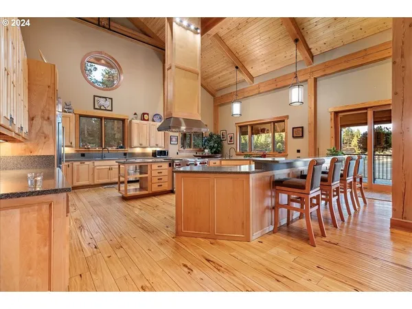 a open kitchen with stainless steel appliances granite countertop a stove and a white cabinets