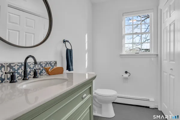 a bathroom with a toilet sink and mirror
