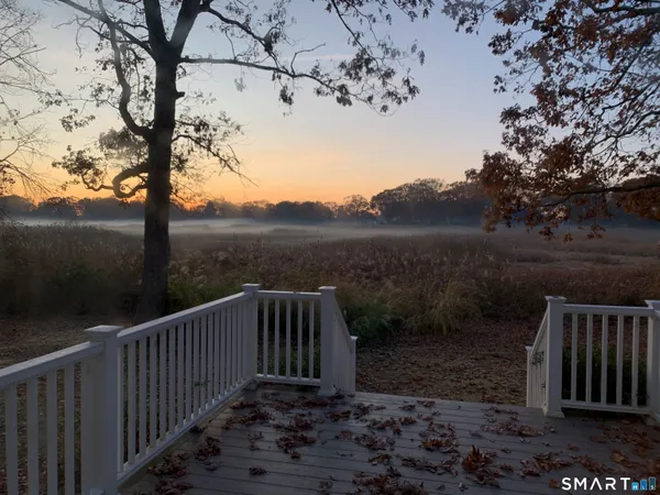 a view of backyard with deck and outdoor seating