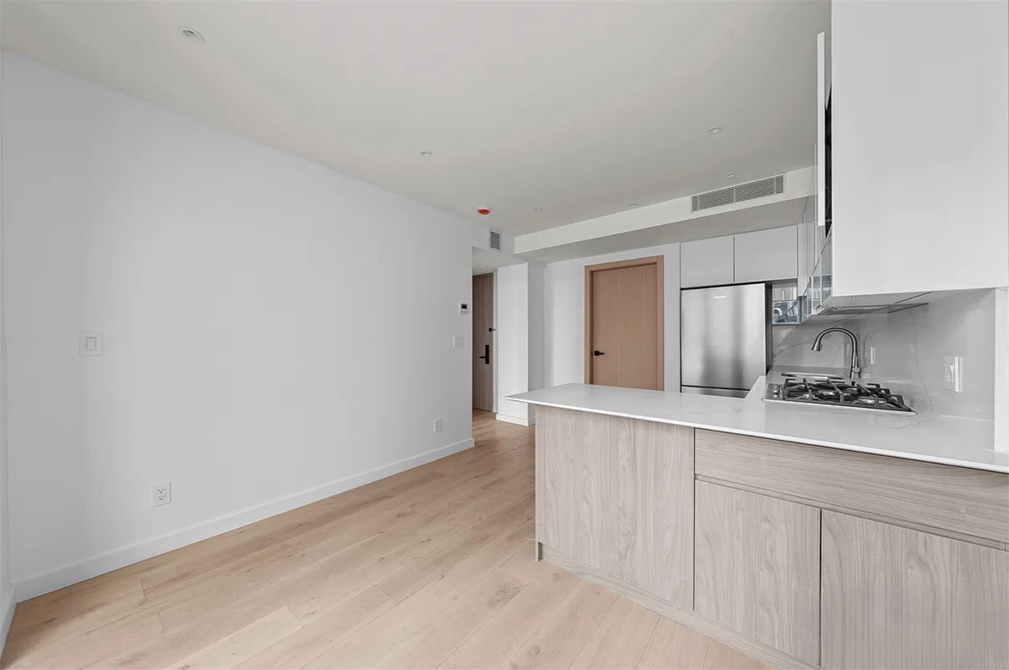 42-62 Hunter Street, Unit 4B Queens, NY 11101 - Photo 3 of 6 a kitchen with white cabinets