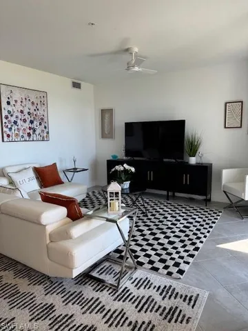 a living room with furniture a rug and a flat screen tv