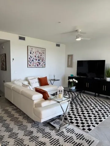 a living room with furniture a flat screen tv and a table