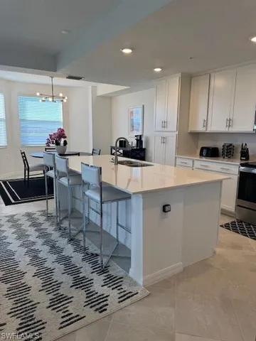 a large kitchen with kitchen island a sink table and chairs