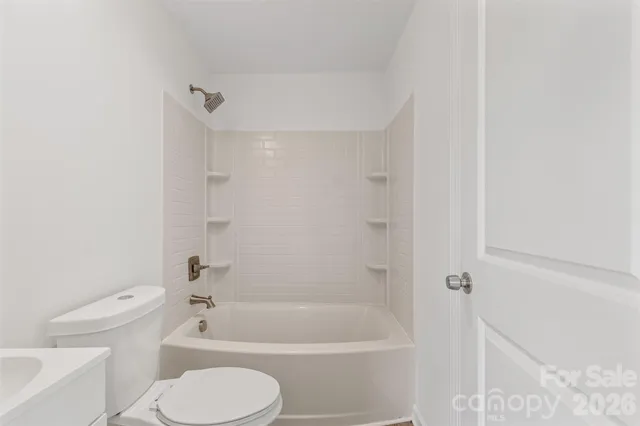 a bathroom with a toilet and a bath tub