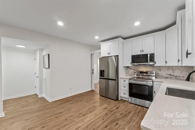 a kitchen with a refrigerator and a stove top oven