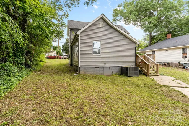 a view of a house with backyard and trees
