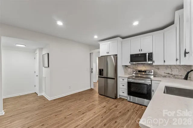 a kitchen with granite countertop a refrigerator and a stove top oven