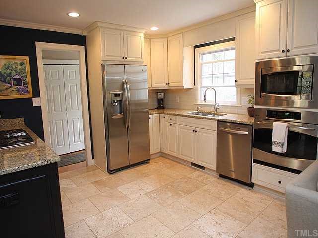 629 Macon Place Raleigh, NC 27609 - Photo 4 of 12 Stainless appliances, new custom cabinets, new fixtures, gorgeous granite and subway tile backsplash, travertine floors. Double doors in the background of this picture hides a large pantry and another refrigerator. In one word this kitchen is AWESOME!