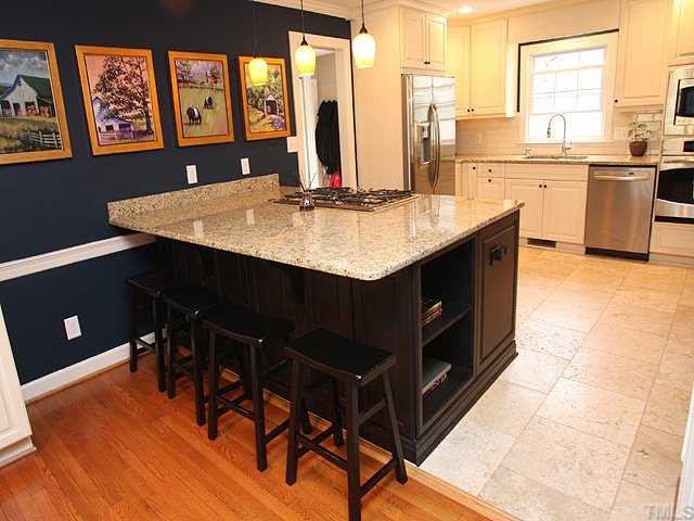 629 Macon Place Raleigh, NC 27609 - Photo 5 of 12 This is the dream kitchen, Grande 8x6 center island with gas cook top, Updated lighting, Wonderful for entertaining ,will inspire the culinary artist in you while creating a warm welcoming atmosphere as it pours into the spacious living area.