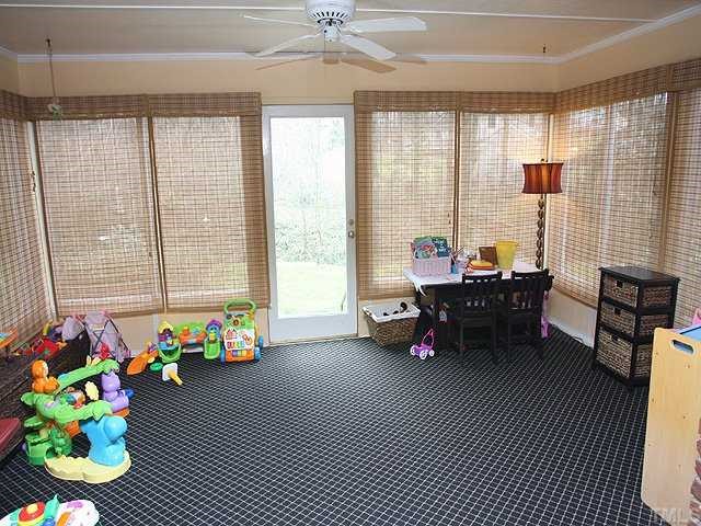 629 Macon Place Raleigh, NC 27609 - Photo 10 of 12 Sunroom currently used as a play space, under the carpet are the twenty inch tiles, access to the back yard. This room is not counted in the overall square footage of the home. It is listed as other.
