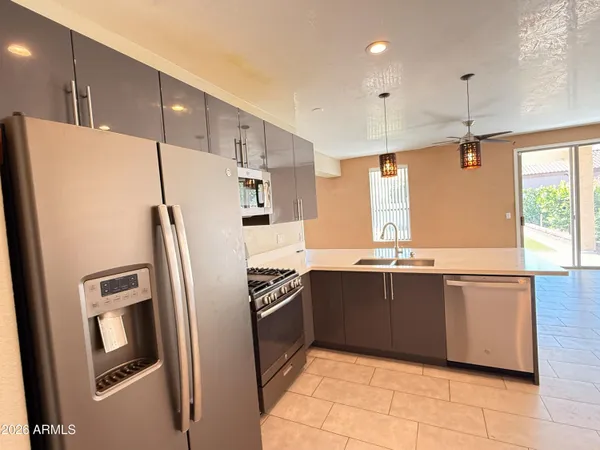 a kitchen with a refrigerator a microwave a stove and cabinets