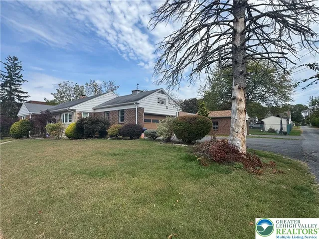 a front view of house with yard and trees