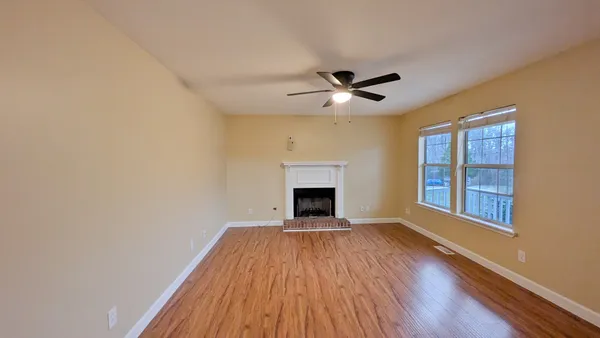a view of an empty room with a fireplace and a window