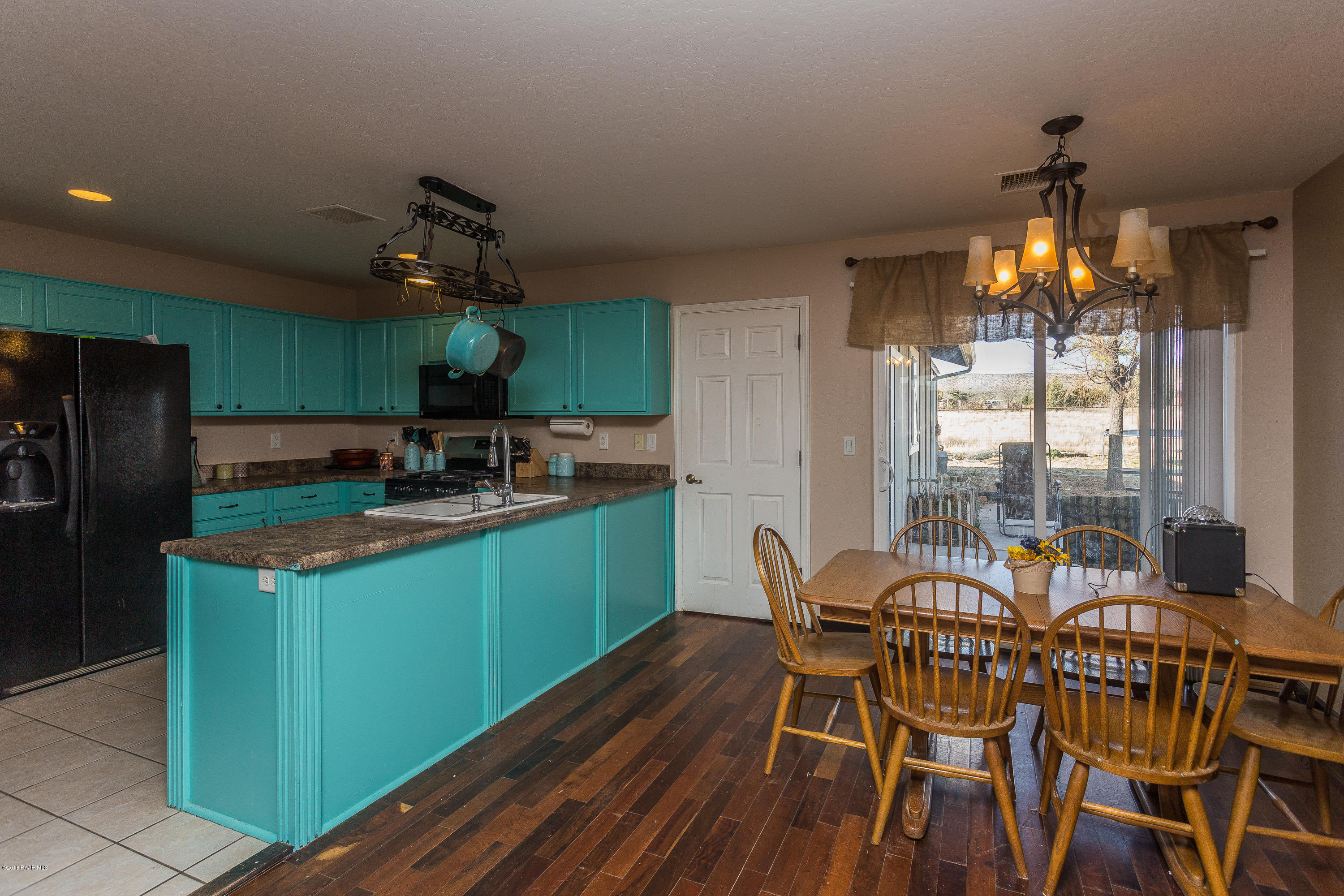 25805 Poppy Road Paulden, AZ 86334 - Photo 5 of 17 a kitchen with stainless steel appliances granite countertop a table chairs and a refrigerator