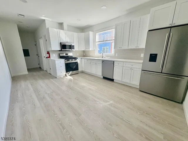 a kitchen with white cabinets and white appliances