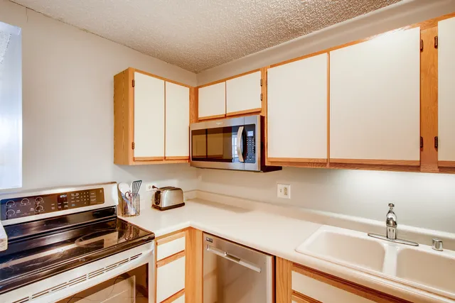 a kitchen with sink a microwave and cabinets