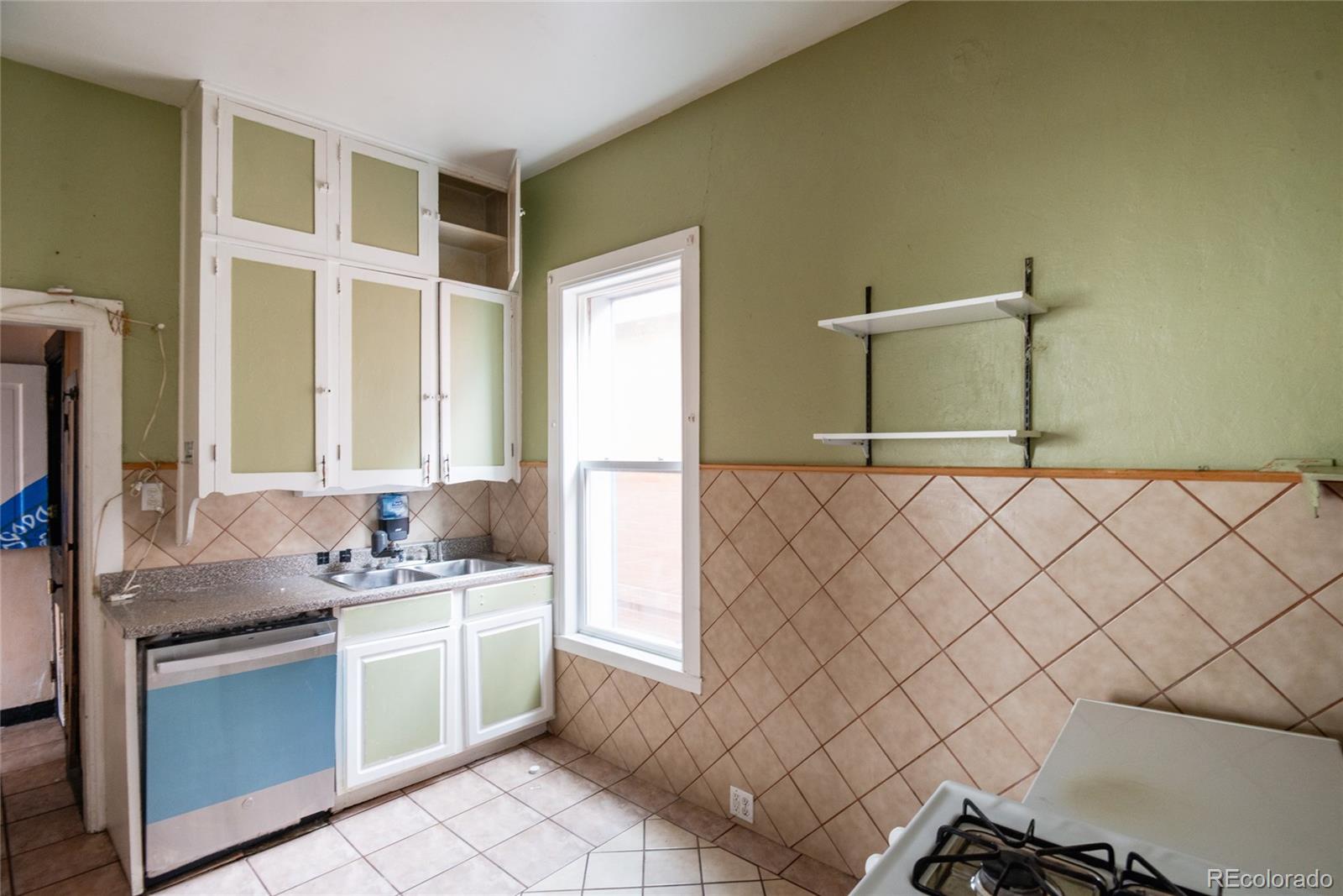 662 South Logan Street Denver, CO 80209 - Photo 7 of 25 a kitchen with a sink cabinets and window