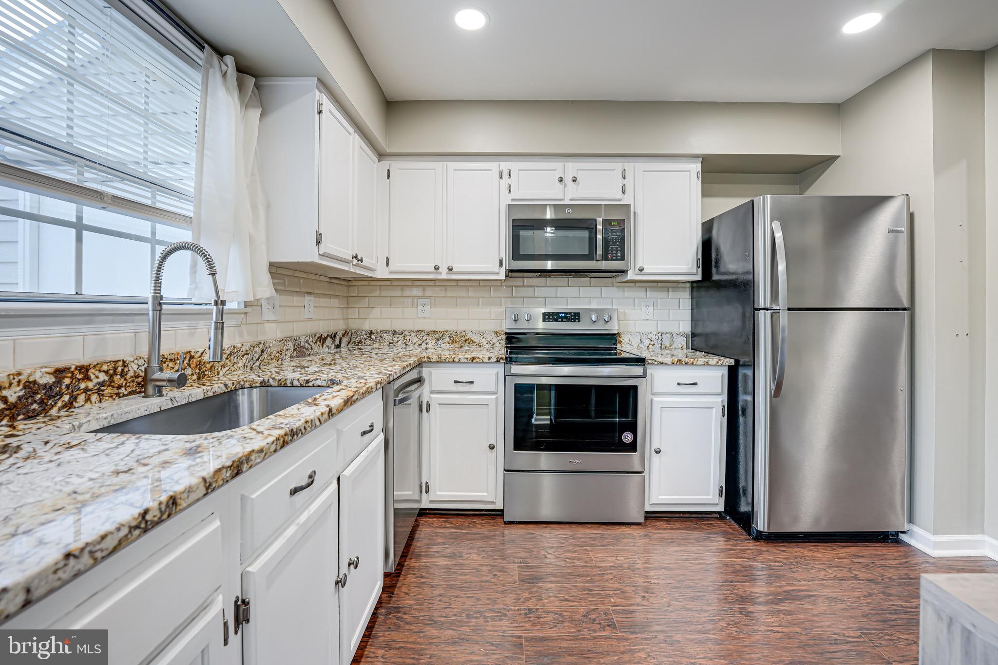 15592 Northgate Drive Dumfries, VA 22025 - Photo 3 of 51 a kitchen with stainless steel appliances granite countertop a refrigerator sink and stove