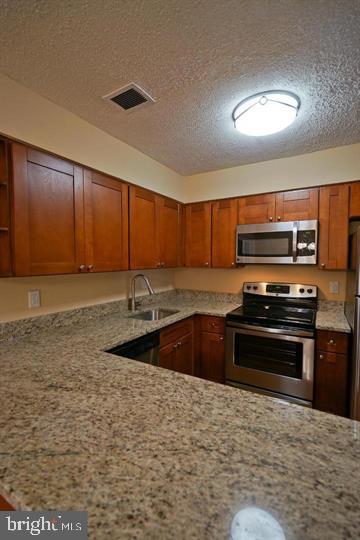 2215 Coppersmith Square Reston, VA 20191 - Photo 13 of 13 a kitchen with stainless steel appliances granite countertop a stove a sink and a microwave