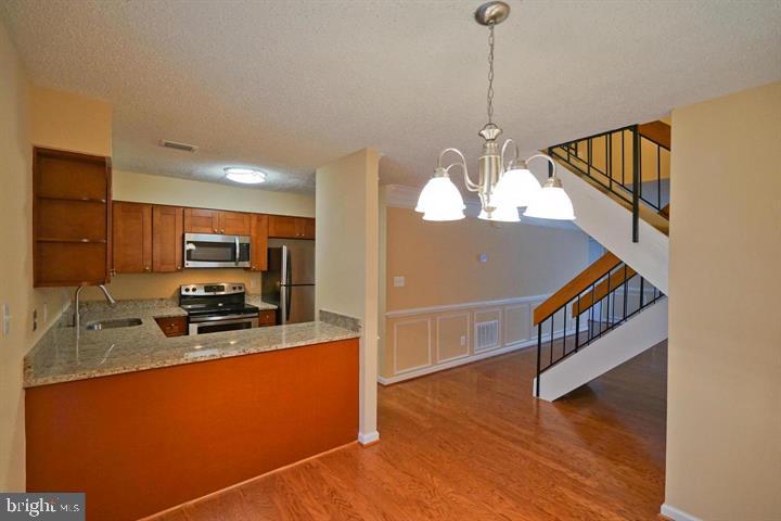 2215 Coppersmith Square Reston, VA 20191 - Photo 3 of 13 a kitchen with stainless steel appliances granite countertop a sink a stove and a refrigerator