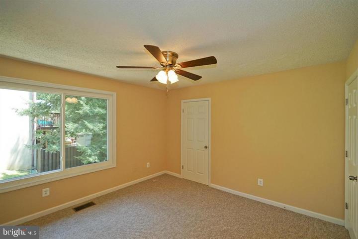 2215 Coppersmith Square Reston, VA 20191 - Photo 9 of 13 an empty room with windows and ceiling fan