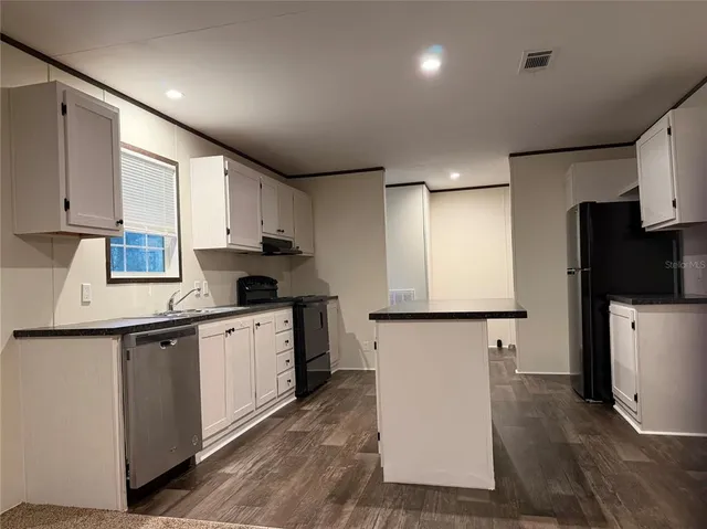 a kitchen with a sink a refrigerator and cabinets