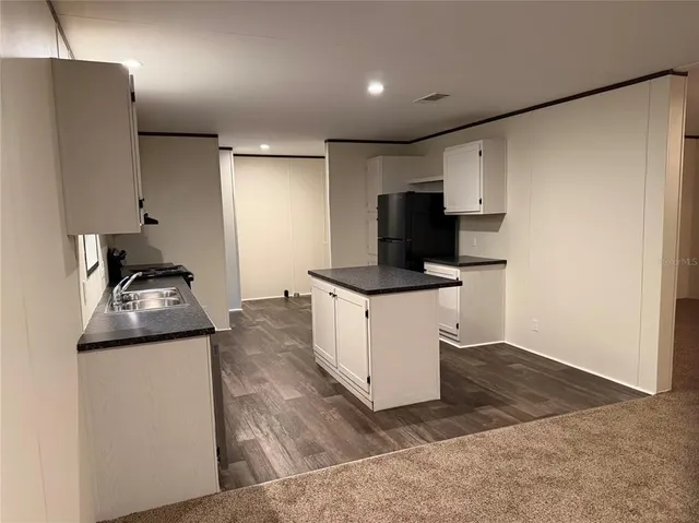 a kitchen with stainless steel appliances kitchen island a refrigerator sink and stove