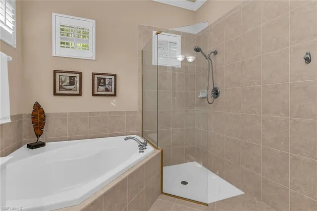 a bathroom with a tub a window and glass door