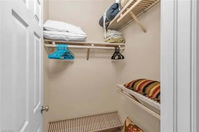 a view of walk in closet with clothes and shoes